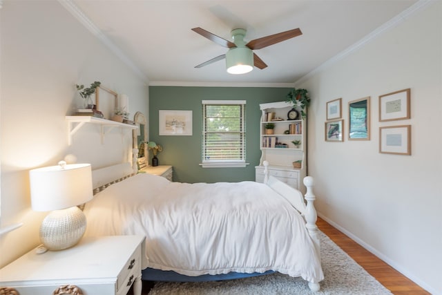 bedroom with crown molding, baseboards, a ceiling fan, and wood finished floors
