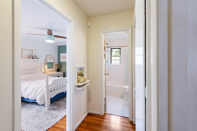 corridor with baseboards and wood finished floors