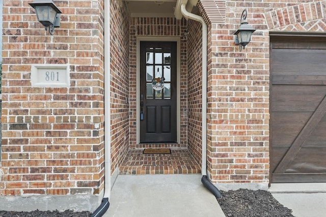 doorway to property featuring brick siding