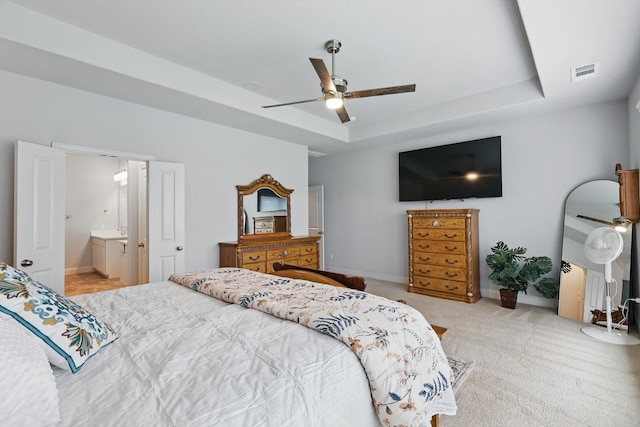 bedroom featuring carpet, a ceiling fan, baseboards, a tray ceiling, and visible vents