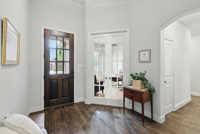 foyer featuring arched walkways, baseboards, french doors, and dark wood-style flooring