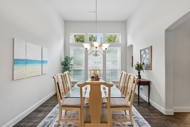 dining area featuring baseboards, a notable chandelier, dark wood-style floors, and visible vents