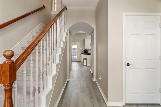 6401 Marlar Ln, The Colony, TX 75056 - hall featuring arched walkways, wood finished floors, baseboards, and stairway