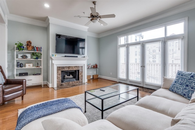 living area with ornamental molding, wood finished floors, ceiling fan, recessed lighting, and a high end fireplace