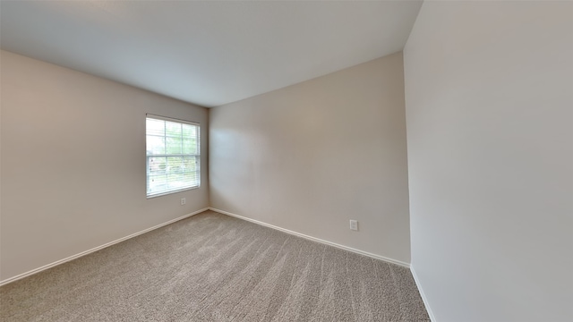 carpeted empty room with baseboards