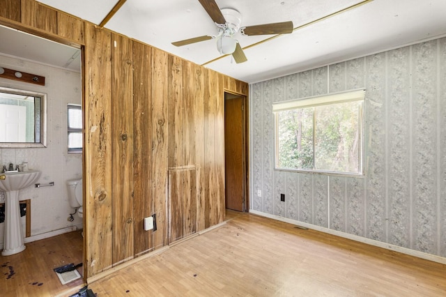unfurnished bedroom featuring baseboards, ceiling fan, and wood finished floors