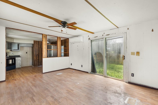 unfurnished living room with a ceiling fan, light wood-style flooring, and a wall mounted air conditioner
