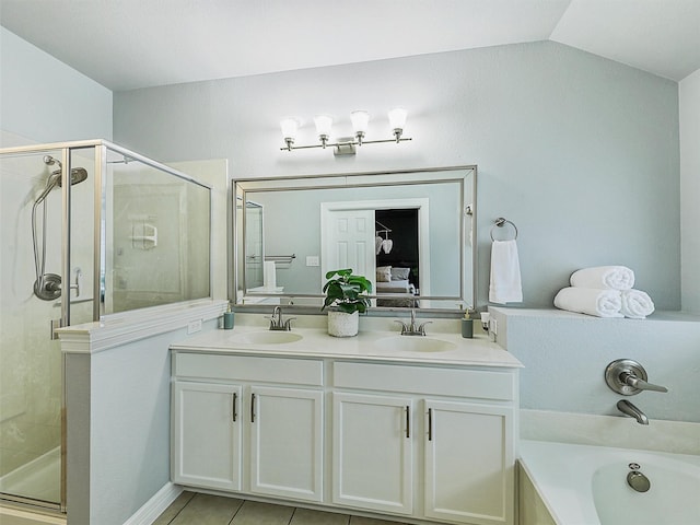 ensuite bathroom with double vanity, a sink, and a shower stall