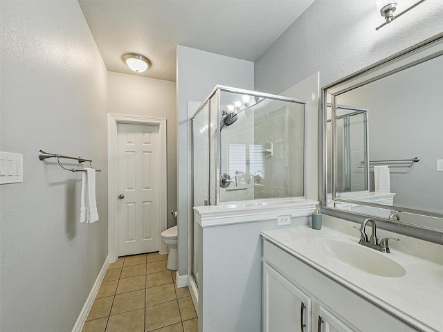 full bath with tile patterned flooring, a stall shower, vanity, baseboards, and toilet