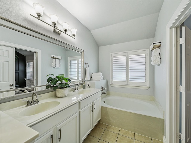 bathroom featuring a sink, tile patterned flooring, a bath, and lofted ceiling