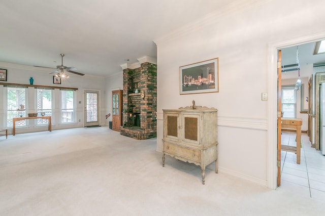 living room with baseboards, ornamental molding, ceiling fan, and light carpet