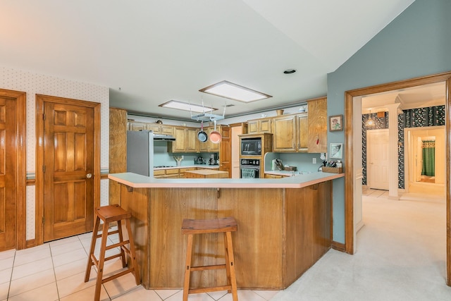 7917 Kendra Ln, North Richland Hills, TX 76182 - kitchen with black microwave, oven, a peninsula, light countertops, and freestanding refrigerator