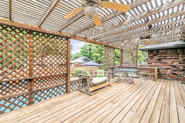 wooden deck with a pergola, fence, a ceiling fan, and outdoor dining space