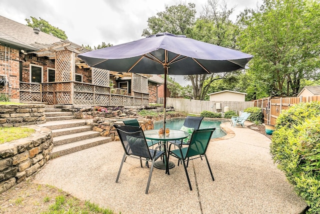 view of patio / terrace featuring a fenced backyard, a fenced in pool, a pergola, and outdoor dining space