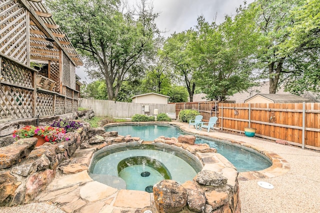 view of swimming pool featuring a fenced backyard and a pool with connected hot tub