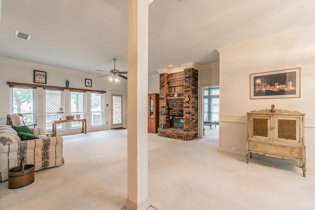 living room featuring crown molding, ceiling fan, light colored carpet, a fireplace, and visible vents