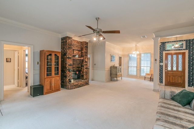 living room featuring crown molding, a fireplace, light colored carpet, a wainscoted wall, and ceiling fan with notable chandelier