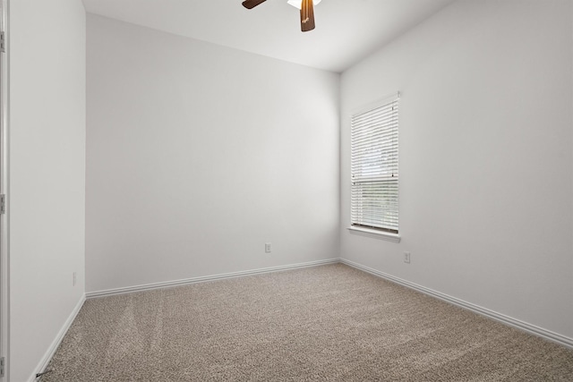 spare room with carpet floors, ceiling fan, and baseboards