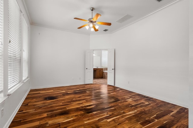 spare room featuring ceiling fan, visible vents, wood finished floors, baseboards, and ornamental molding