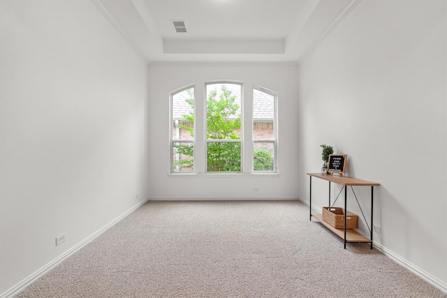 carpeted empty room featuring baseboards, visible vents, and a raised ceiling