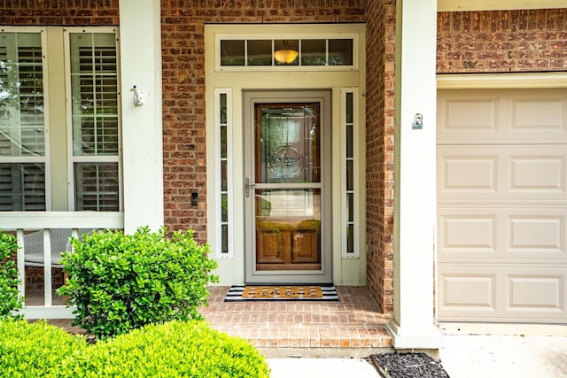 property entrance with a garage, a porch, and brick siding