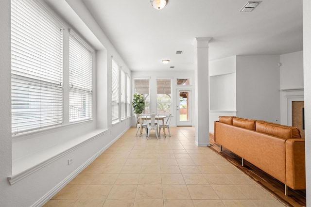 interior space with baseboards, decorative columns, light tile patterned flooring, and visible vents