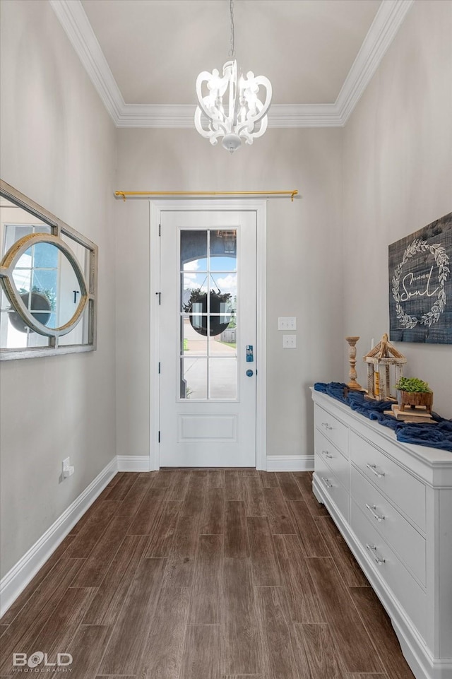 doorway featuring baseboards, ornamental molding, dark wood-type flooring, and a notable chandelier