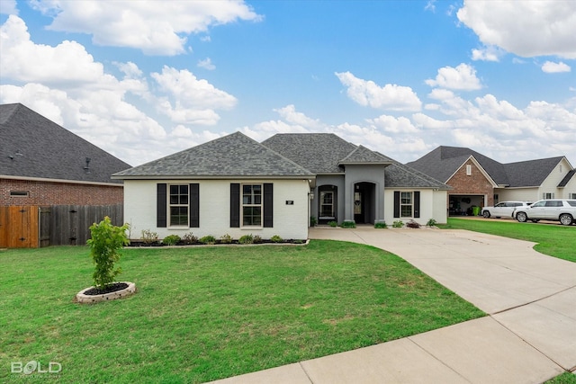 view of front of property featuring fence, a front yard, brick siding, a shingled roof, and concrete driveway