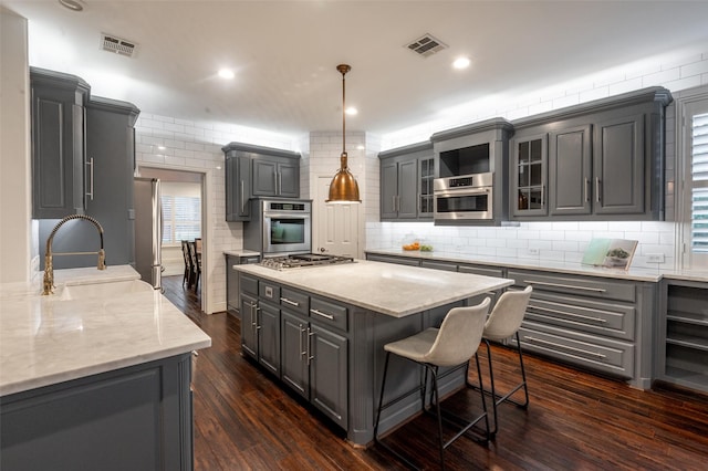 kitchen with visible vents, a sink, gray cabinetry, and stainless steel appliances