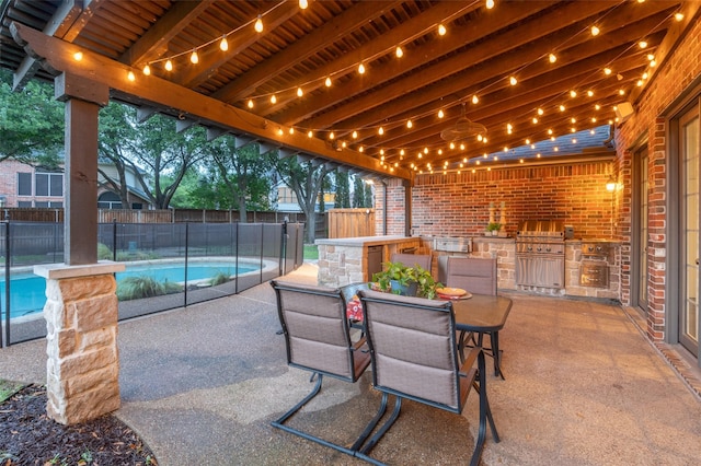 view of patio / terrace with a grill, a fenced backyard, an outdoor kitchen, a fenced in pool, and outdoor dining space