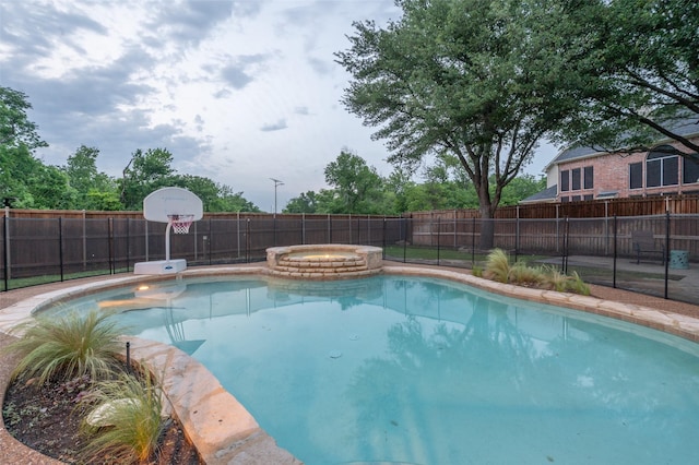 view of pool featuring a fenced backyard and a pool with connected hot tub