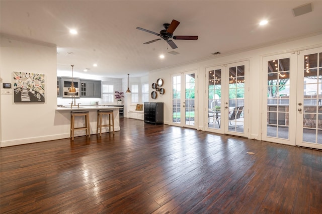 living area with a ceiling fan, french doors, ornamental molding, recessed lighting, and dark wood-type flooring