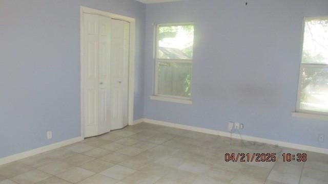 empty room featuring plenty of natural light and baseboards