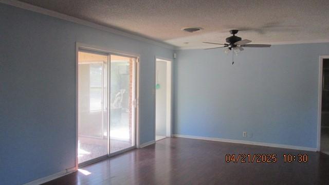 unfurnished room with ceiling fan, a textured ceiling, crown molding, wood finished floors, and baseboards