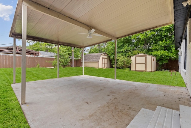 view of patio / terrace with ceiling fan, an outbuilding, a shed, and a fenced backyard