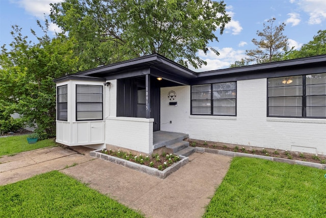 view of front of home featuring brick siding and a front yard