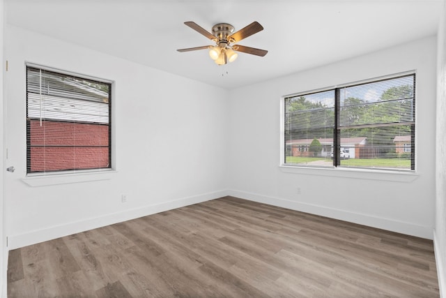 empty room featuring light wood-style floors, baseboards, and ceiling fan