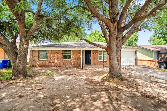 single story home with concrete driveway and brick siding