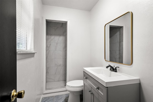 bathroom featuring vanity, a shower stall, toilet, and marble finish floor