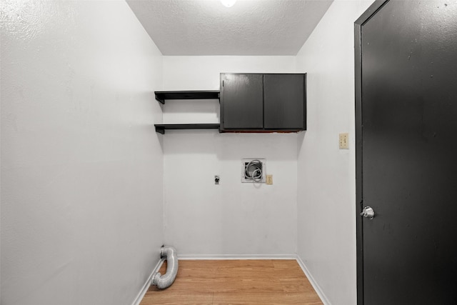 laundry area with cabinet space, light wood finished floors, a textured ceiling, baseboards, and hookup for an electric dryer