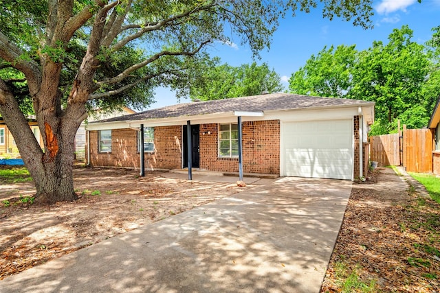 ranch-style house with brick siding, a garage, fence, and concrete driveway