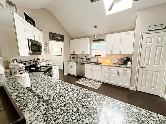 kitchen featuring ceiling fan, a sink, stainless steel appliances, backsplash, and vaulted ceiling