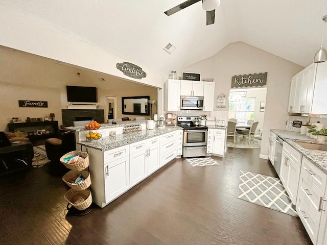 kitchen featuring visible vents, a peninsula, lofted ceiling, stainless steel appliances, and white cabinetry