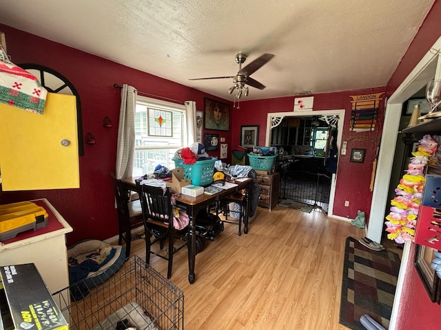 dining area featuring a ceiling fan, a textured ceiling, and wood finished floors