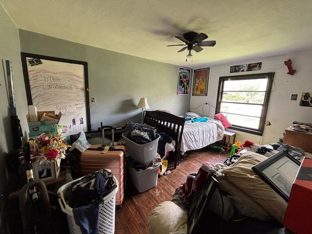 bedroom with a textured ceiling, a ceiling fan, and wood finished floors