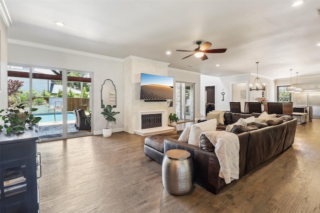 living room featuring recessed lighting, ceiling fan with notable chandelier, wood finished floors, and a fireplace
