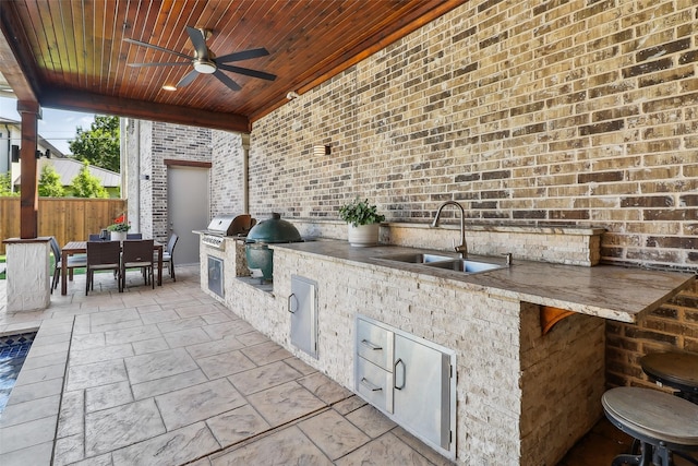 view of patio with ceiling fan, outdoor dining space, a sink, and area for grilling