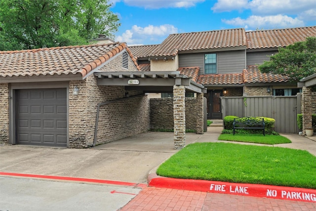 view of front of house with a tiled roof, an attached garage, fence, and concrete driveway