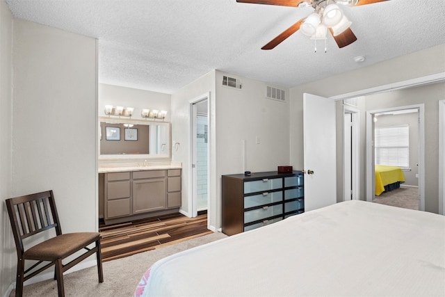 bedroom featuring carpet flooring, a textured ceiling, and visible vents