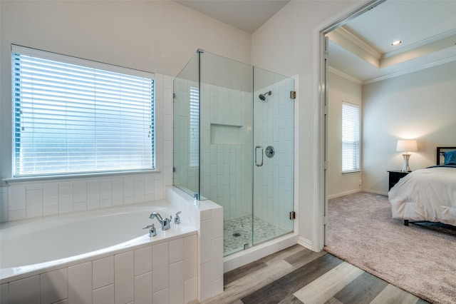 ensuite bathroom with crown molding, wood finished floors, ensuite bathroom, a garden tub, and a stall shower